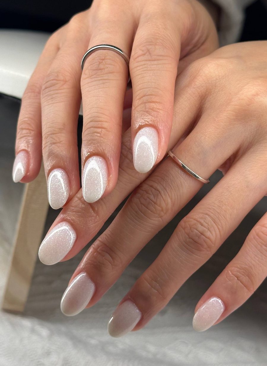 Milky white shimmer almond nails with a clean cuticle line